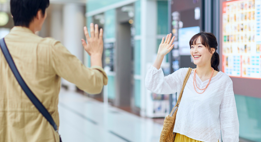 A smiling woman waves back at a friend, illustrating how familiar narrative cues can reappear at the right moment to guide users back into your SaaS product flow.