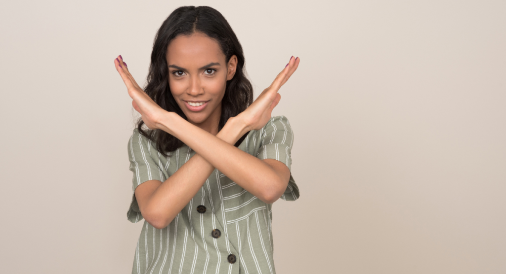 A woman makes an “X” gesture with her arms, symbolizing users who finish onboarding but quickly disengage when the product story doesn’t show a clear path to success.