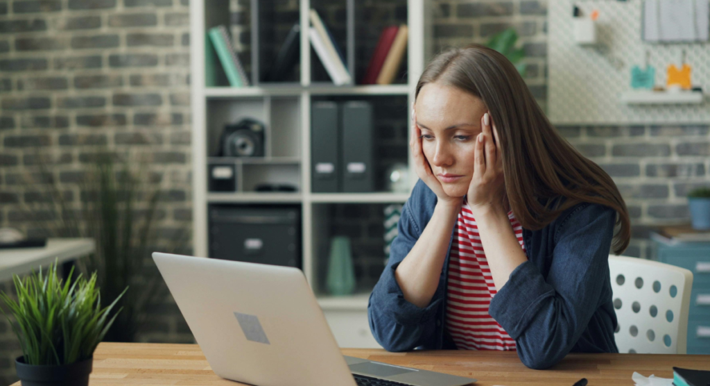 Woman staring at her laptop in frustration, reflecting how users feel when a landing page lacks the clear narrative they expect.