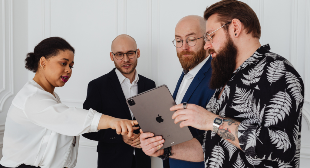 Team reviewing a product demo on a tablet, illustrating how introducing features too early weakens the homepage story.