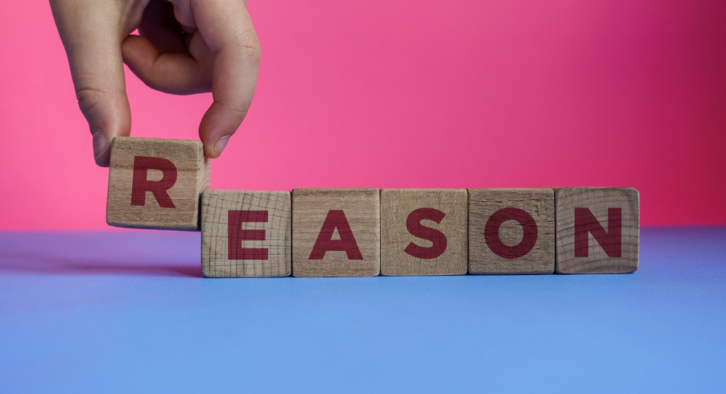Hand arranging wooden blocks that spell “REASON,” illustrating the core cause behind why many landing pages fail to convert.