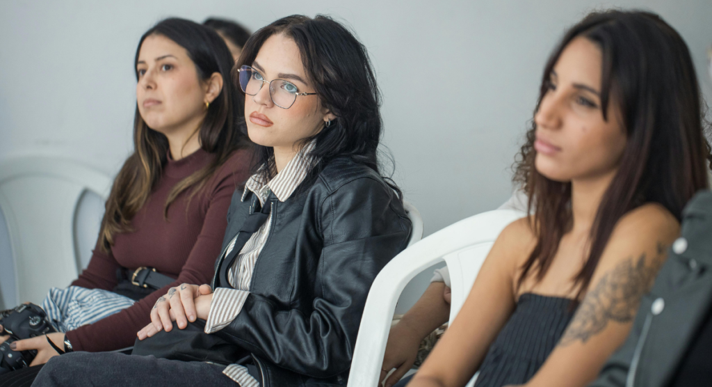 Audience members listening intently, showing how clear, simple framing helps a story land without overwhelming the reader.