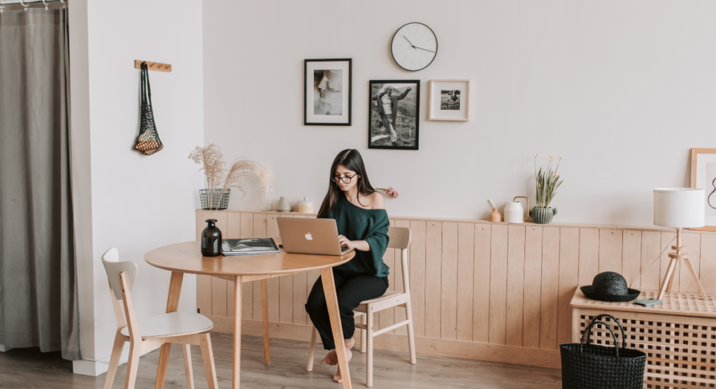 A founder works from a calm home workspace, reflecting on the story behind her SaaS product before investing in ads or demand gen to amplify it.
